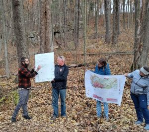 People outside in cool fall weather looking at geological maps.
