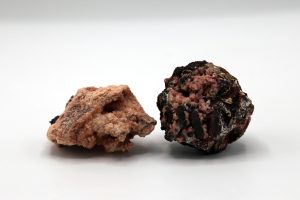 Two hand samples with small pink rhodochrosite crystals.
