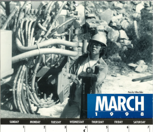 Black and white image of Moe in a hard hat on a drill site in the 1990s with the words "March 1998"